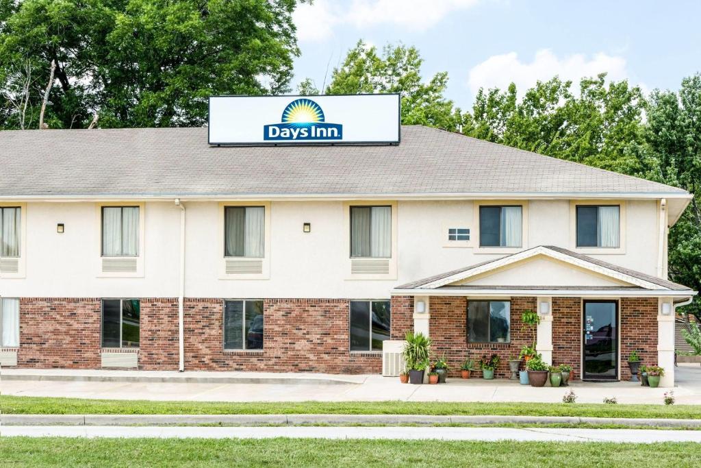 a building with a dogs inn sign on it at Days Inn by Wyndham Warrensburg in Warrensburg