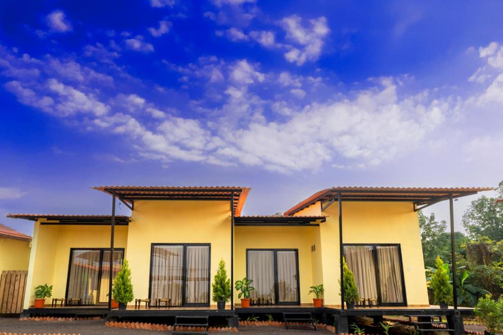 a house with a blue sky in the background at Aavaas Farm Hostel in Gangāpur