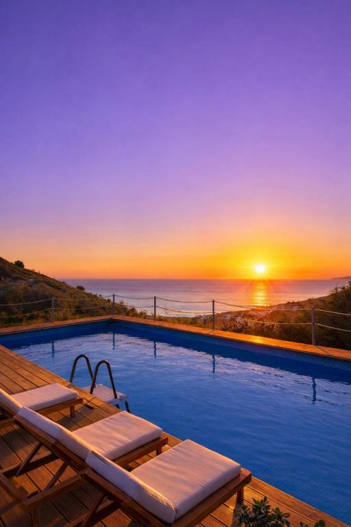 a pool with a view of the ocean at sunset at Grand Seaview Apartments in Ksamil