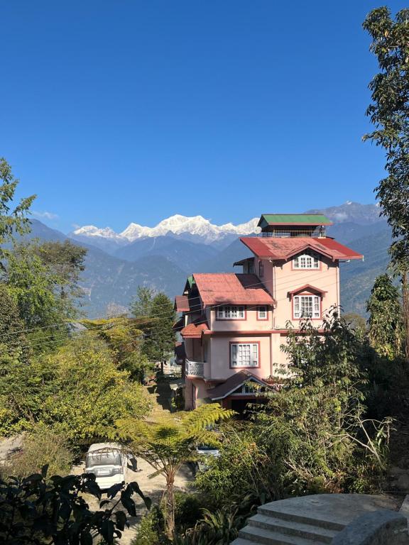 a house on a hill with mountains in the background at Ifseen Villa in Pelling