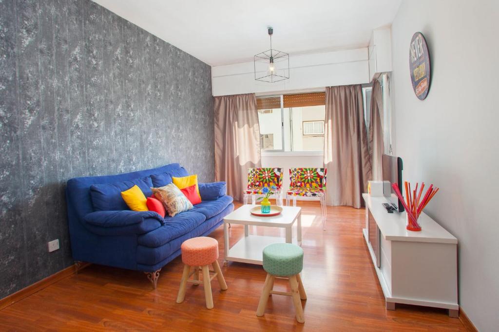 uma sala de estar com um sofá azul e uma mesa em Suite For You em Nicósia