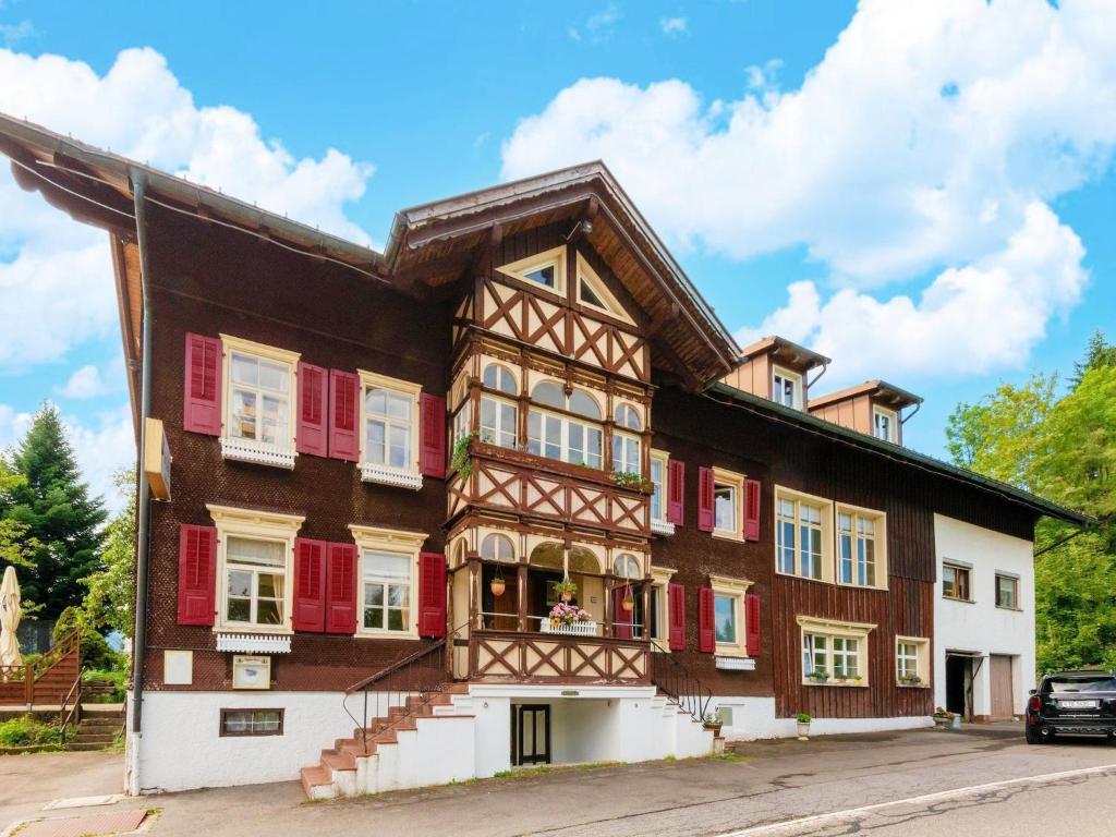 a building with red shutters on the side of it at Holiday apartment in Bregenzerwald in Sibratsgfäll