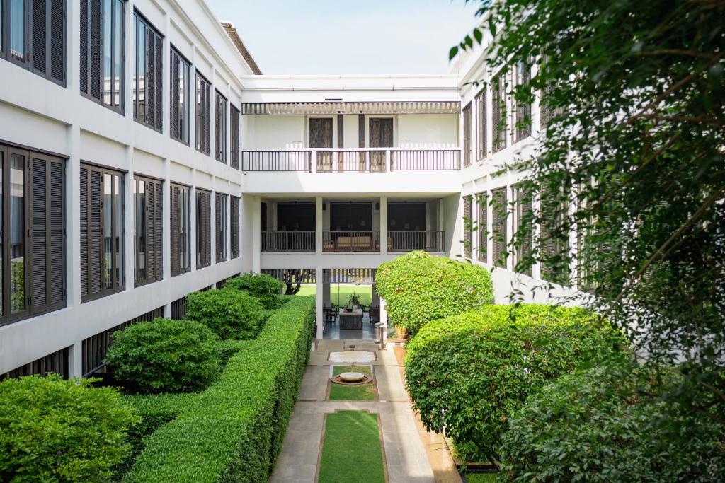 an internal courtyard of a building with bushes and trees at Aruntara Riverside Boutique Hotel in Chiang Mai
