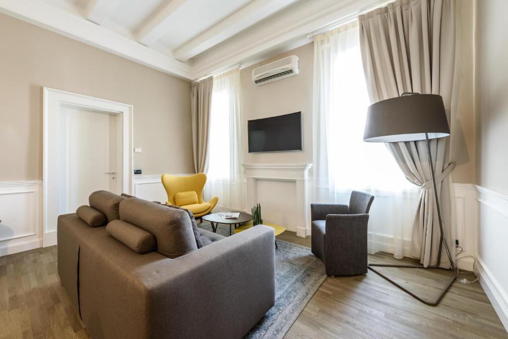 een woonkamer met een bank en twee stoelen bij Palazzo Bovio - Boutique Apartments in Padua