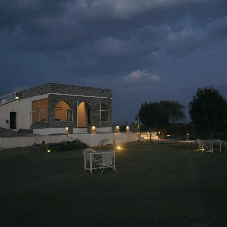 a building with a table in a yard at night at Innara Hospitality in Mori Bera