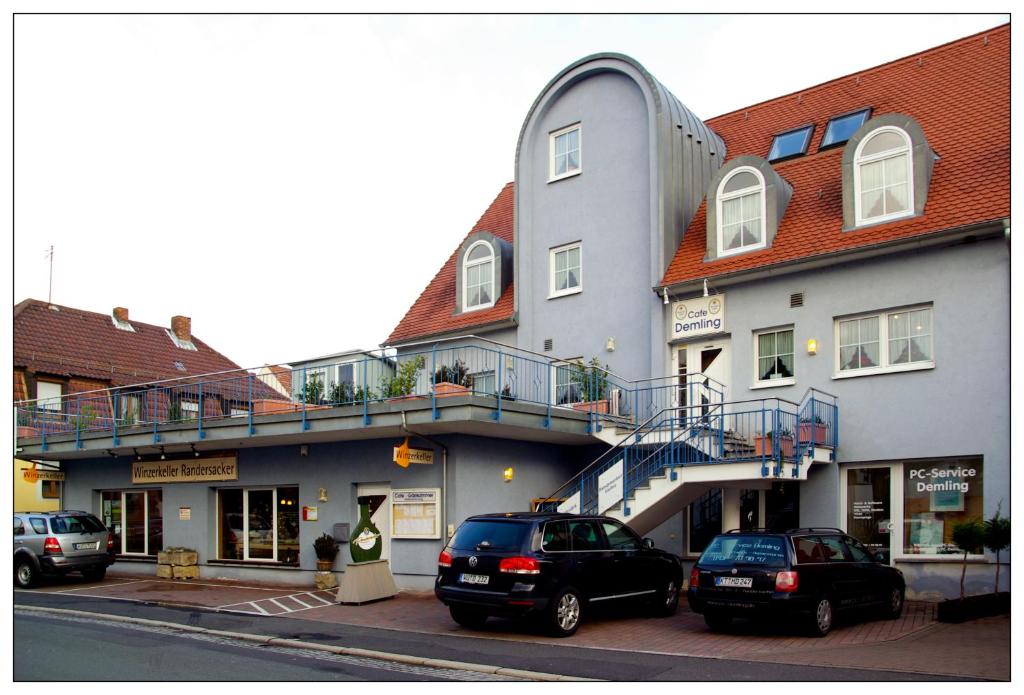 dos coches estacionados frente a un edificio en Hotel-Cafe Demling en Randersacker