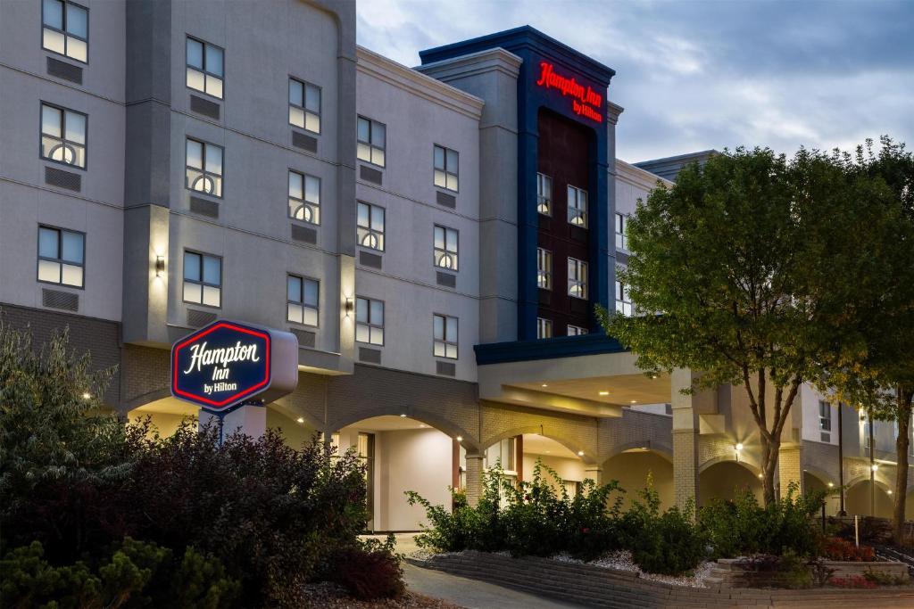 a hotel with a sign in front of a building at Hampton Inn by Hilton Kamloops in Kamloops