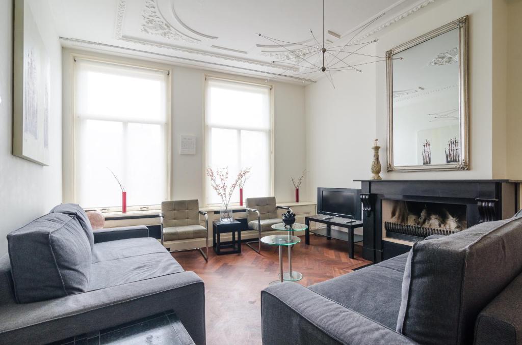a living room with two couches and a fireplace at Marnix360apartments Classic in Amsterdam