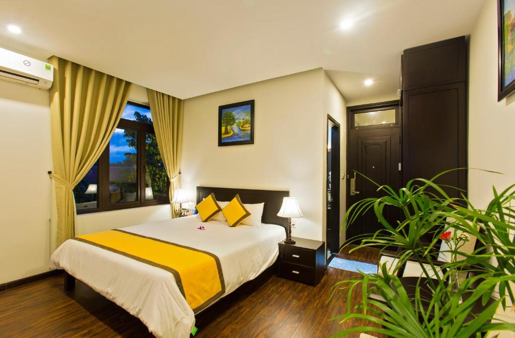 Postel nebo postele na pokoji v ubytování Hoi An Hai Au Boutique Hotel