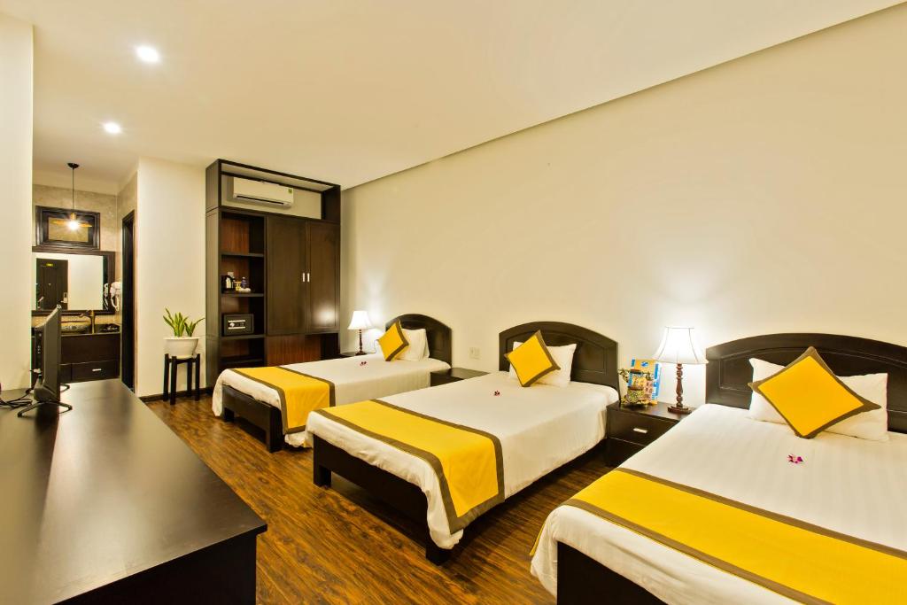 Postel nebo postele na pokoji v ubytování Hoi An Hai Au Boutique Hotel