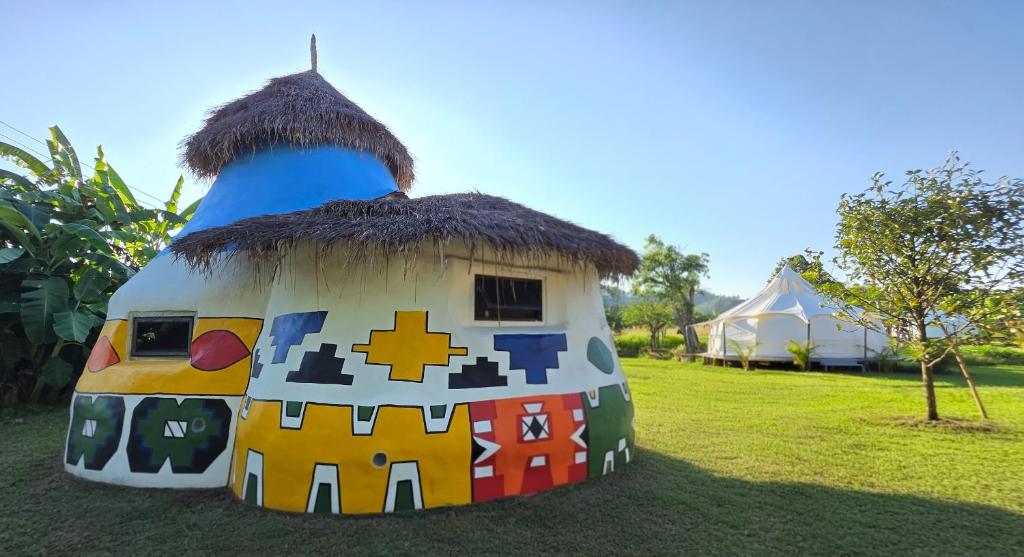 a home shaped like a house with a grass roof at OneSeasonFarm Chiangsaen in Chiang Saen