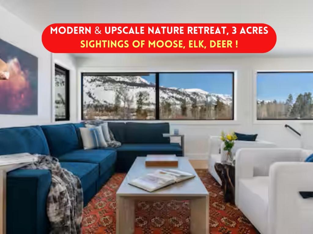 a living room with a blue couch and a table at Secluded Mountain View Getaway - Near Jackson Hole - BBQ, Patio Wildlife! in Wilson