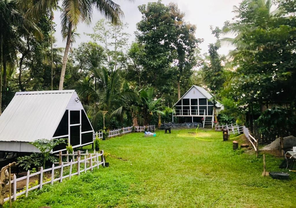 a yard with a barn and a house at The Wildcamp - Coorg in Kushālnagar