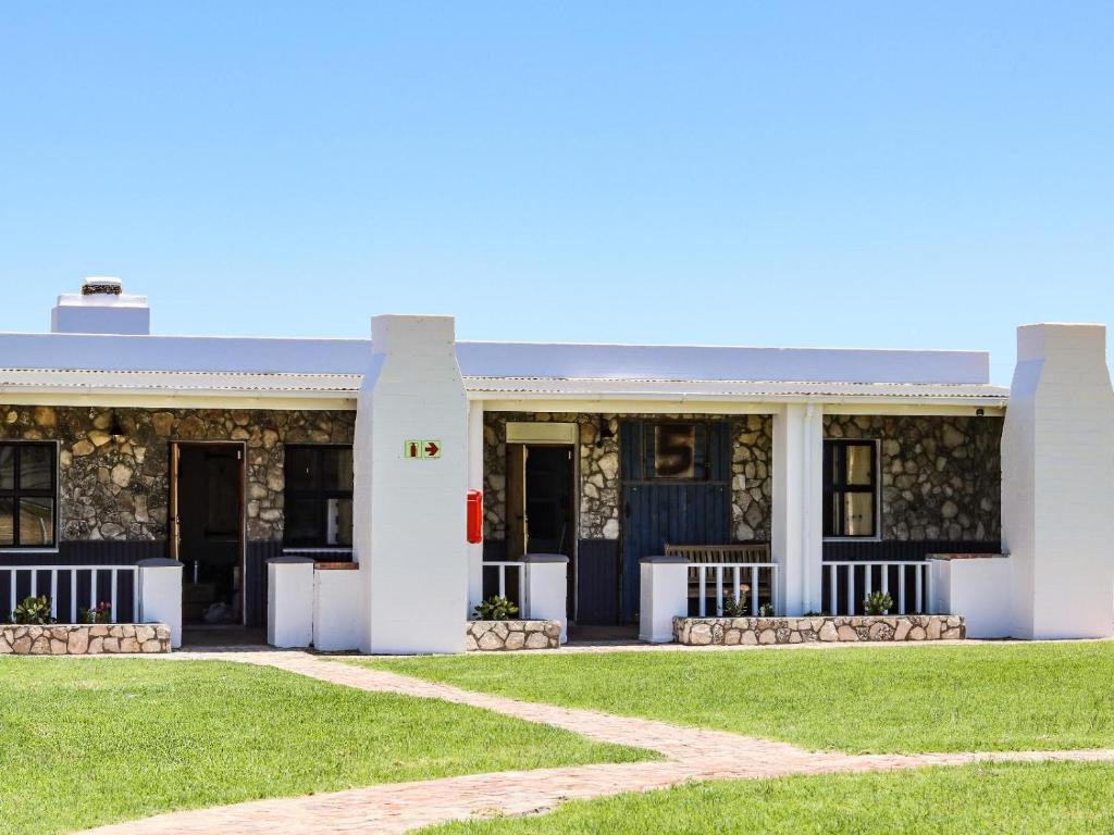 a white building with a lawn in front of it at Die Stalle by Chickania in Jacobs Bay