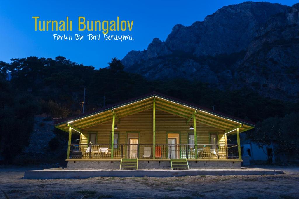 a log cabin with a porch in front of a mountain at Turnalı Bungalow in Kıranköy