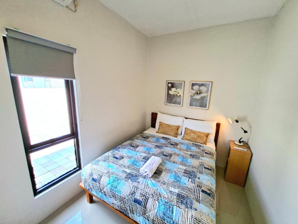 a small bedroom with a bed and a window at Tio Homestay in Praya