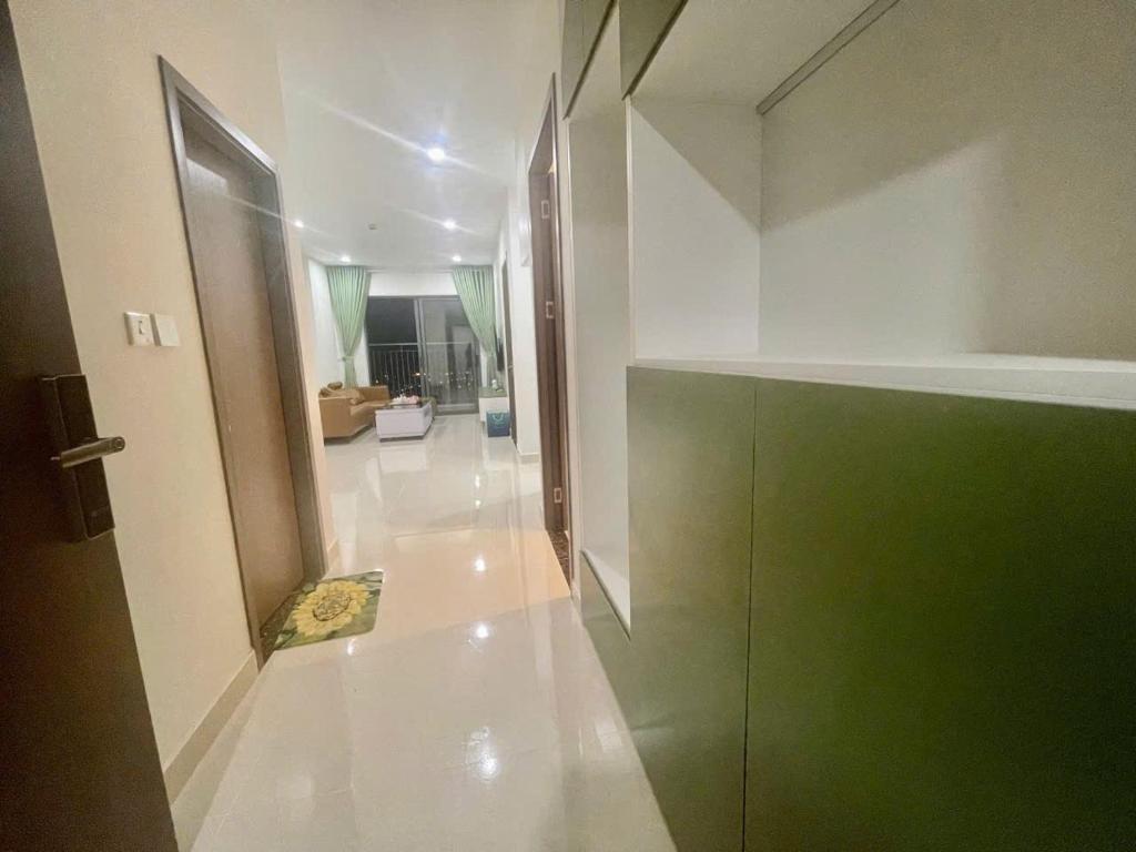 a room with a hallway with a green door at Rạng homestay in Quy Nhon