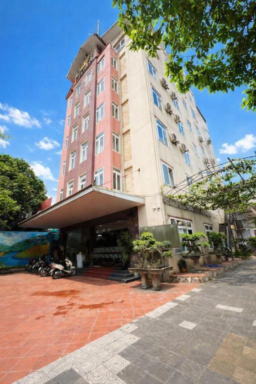 a tall pink building with a lot of plants in front of it at Crown Hotel in Thái Nguyên