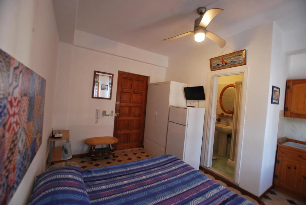 1 dormitorio con 1 cama y nevera en Lipari Monolocale centro storico, en Lipari