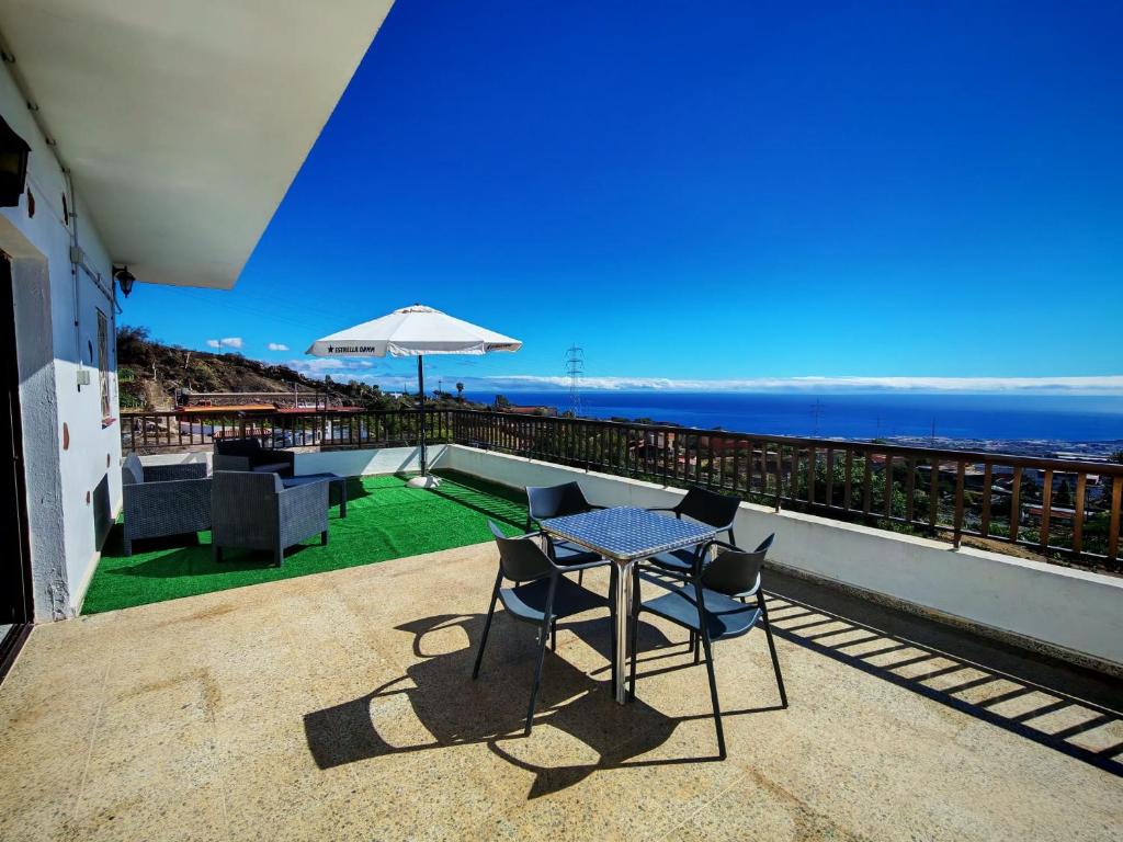 a patio with a table and chairs and the ocean at Finca Hoya del Pino in Arafo