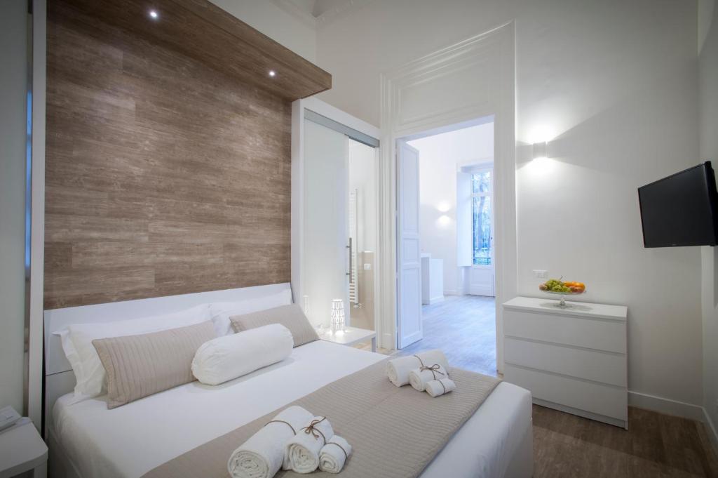um quarto com uma cama branca e toalhas em Politeama Apartments by Giorgio em Palermo