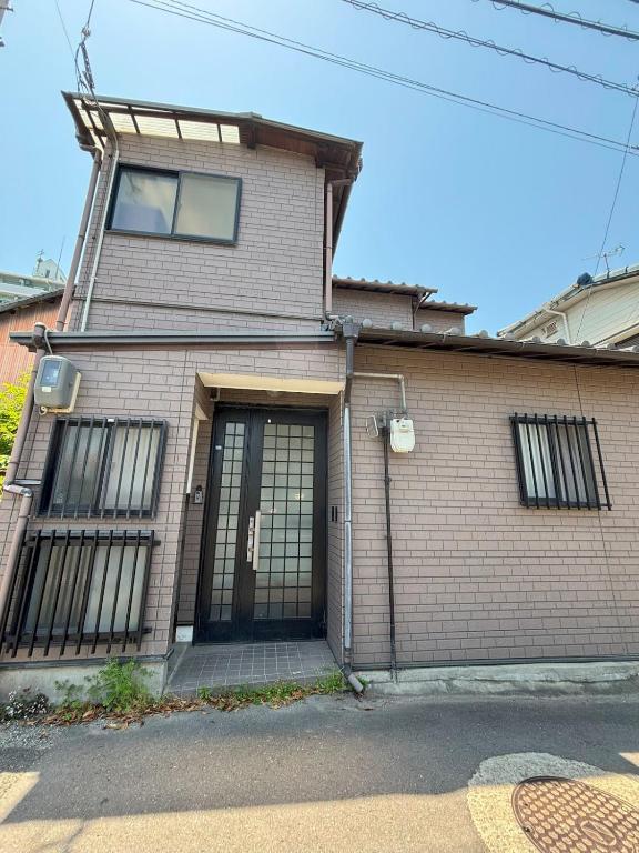 a brick house with a large garage door at 丸亀 Sawau 丸亀駅まで徒歩8分 うどん屋まで徒歩1分 5名まで宿泊可駐車場 1台有 港近 in Marugame