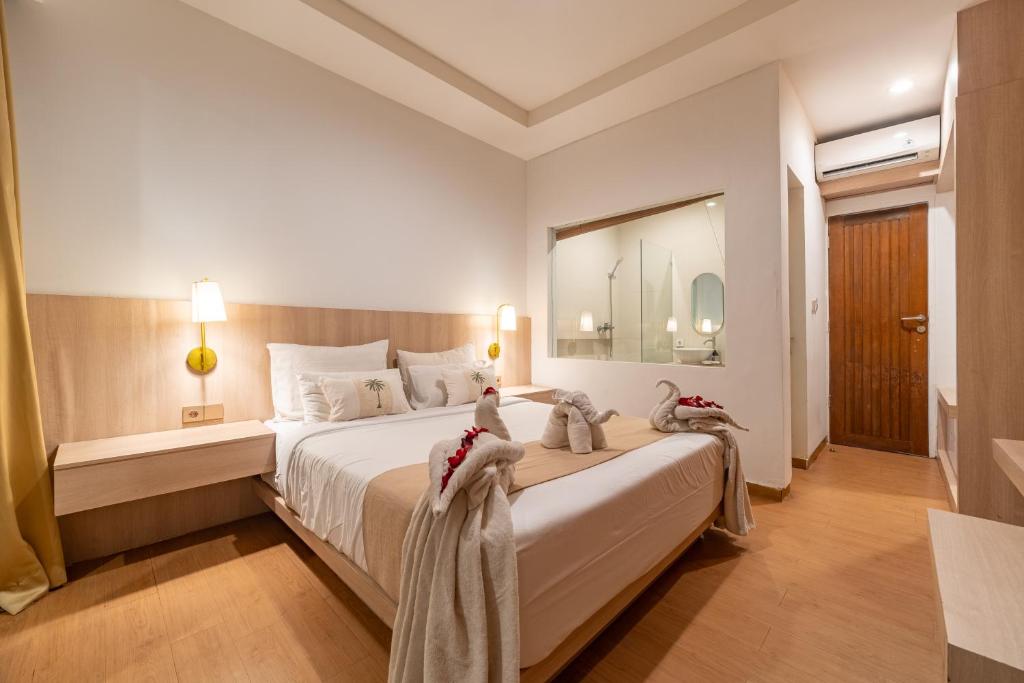 a bedroom with a large bed with towels on it at The Hita Apartement in Seminyak