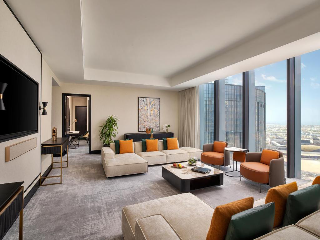 a living room with couches and a tv at Anantara Downtown Dubai in Dubai