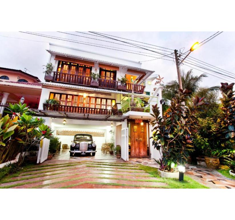 a house with a car parked in front of it at Hotel O Vince Villa in Bukit Mertajam