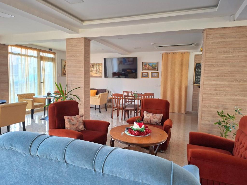 a living room with a blue couch and chairs and a table at Hotel VIVA in Sofia
