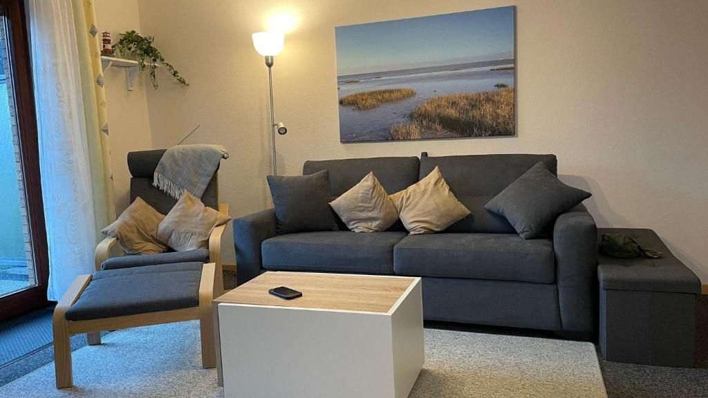 a living room with a blue couch and a table at Ferienwohnung Auszeit Erika 1 in Burhave