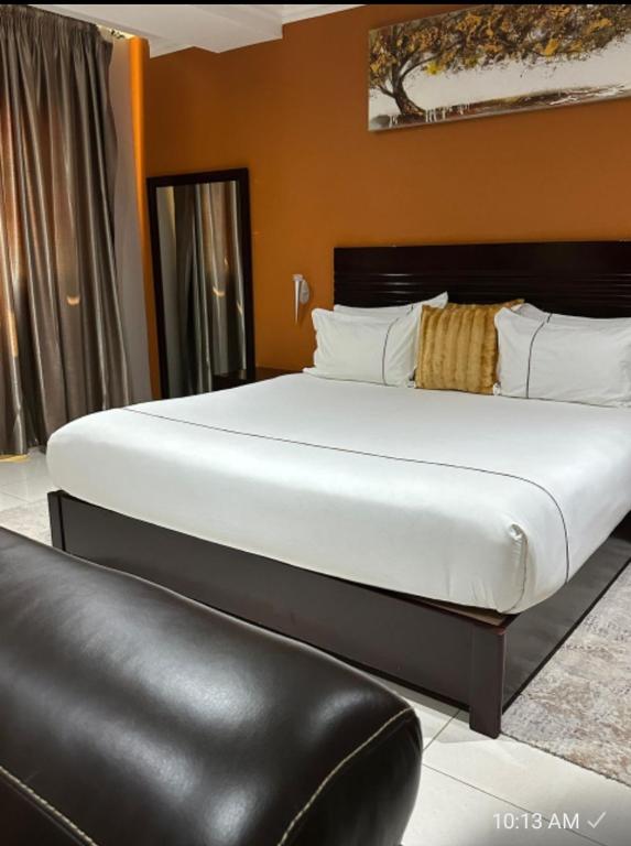 a large bed in a room with a black leather chair at Voyager Inn-Hotel in Palatswe