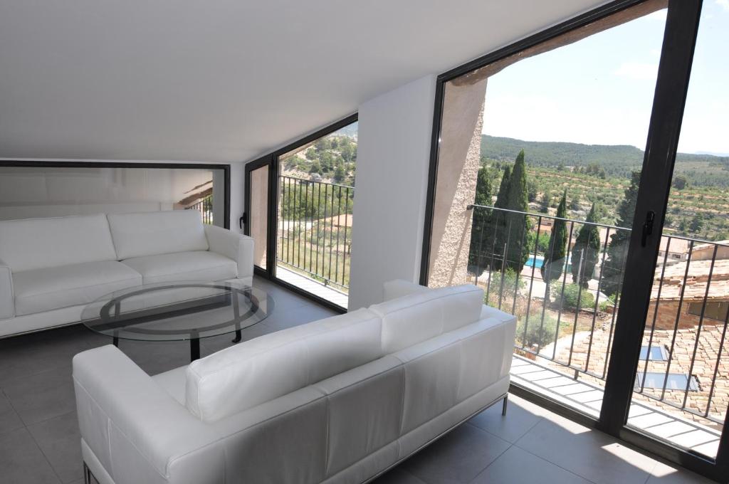 sala de estar con sofá blanco y mesa de cristal en Apartamentos Las Moradas, en La Ginebrosa