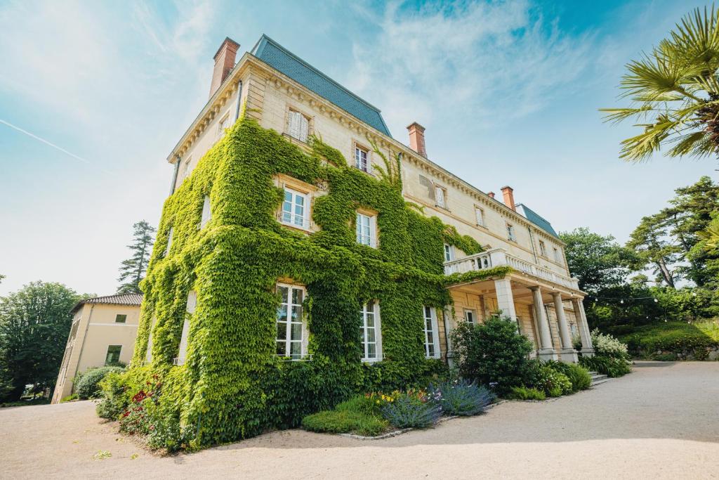 a building covered in green ivy on a building at Château Bellevue-Domaines Loron in Villié-Morgon