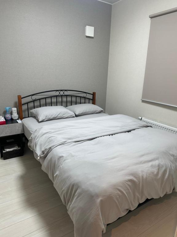 a large white bed in a bedroom with a window at any one in Chitose