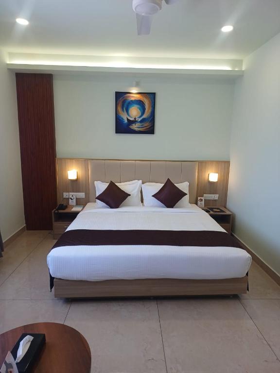 a bedroom with a large bed in a room at Hotel Maas Residency in Māvelikara