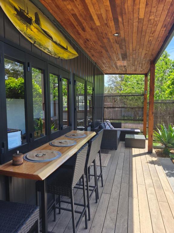 a patio with a table with chairs and a surfboard on it at Tiny House Experience in Sunset Strip