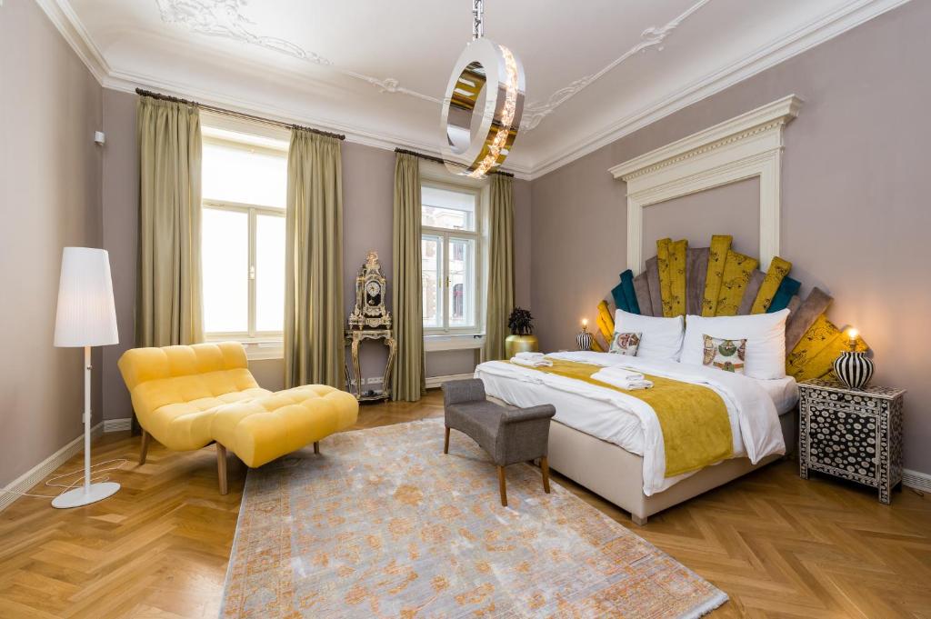 1 dormitorio con 1 cama grande y 1 silla amarilla en Grand Central Residence by TKC, en Praga