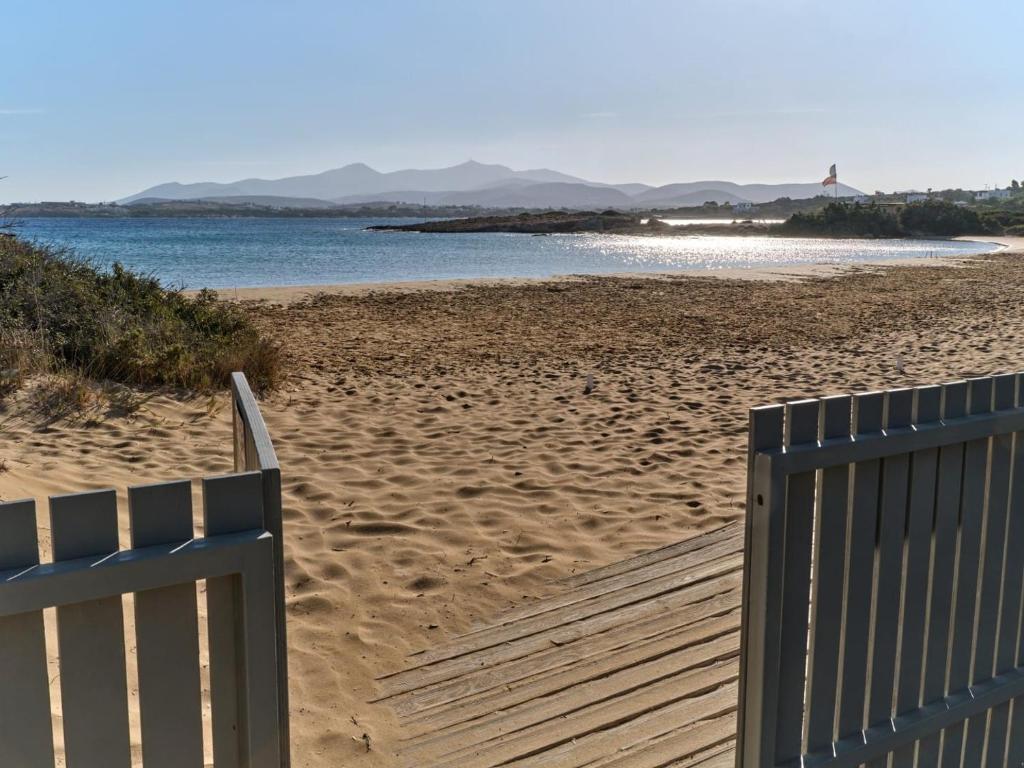 a wooden boardwalk leading to a beach with the ocean at Beach House Mikri Santa Maria in Kournonísi