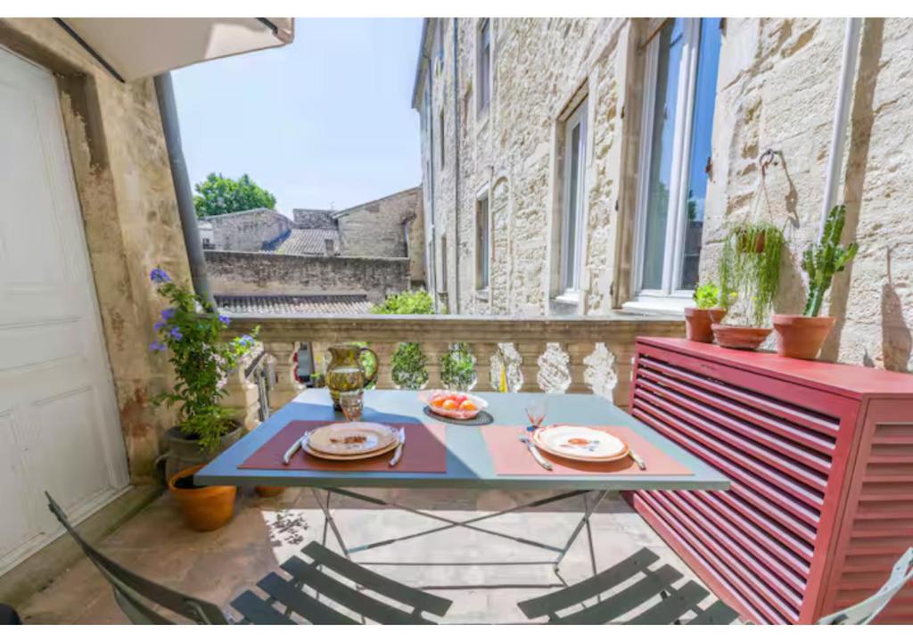 a table with plates on it on a balcony at Goncourt42 in Nîmes