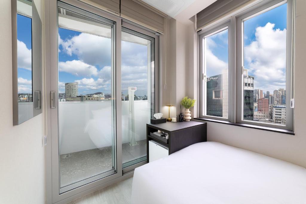 a bedroom with a large window with a view of the city at HiMate Dongdaemun in Seoul