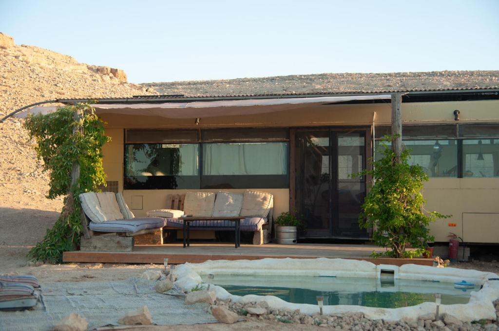 a house with a pool in front of it at אוטובוס בכרם in Mitzpe Ramon