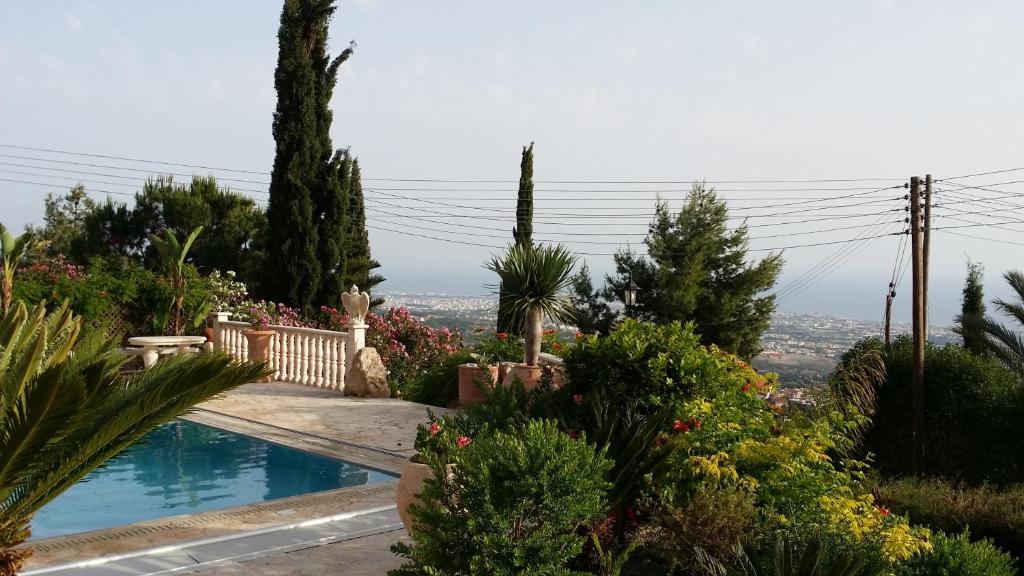 una piscina en un jardín con plantas y árboles en Garden of Eden Villa en Pafos