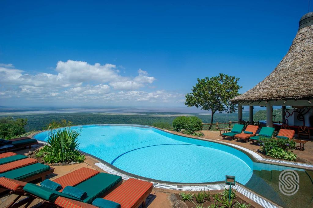 uma piscina com cadeiras e um gazebo em Lake Manyara Serena Safari Lodge em Karatu