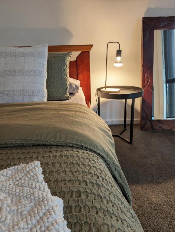 a bedroom with a bed and a table with a lamp at Entire Studio in Moonee Ponds with Free Parking in Melbourne
