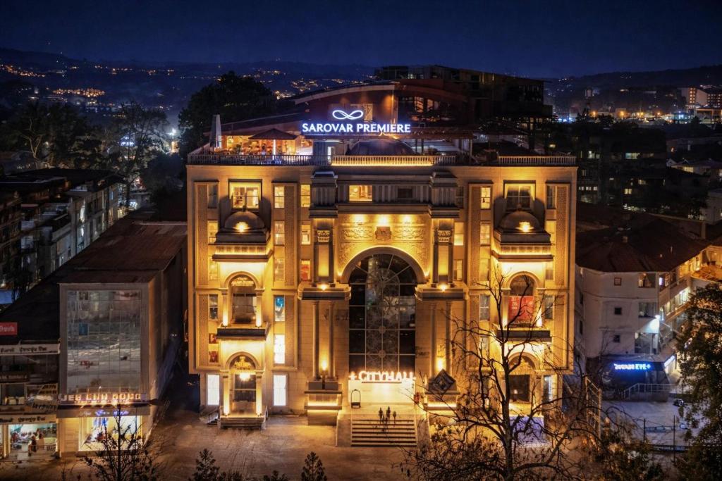 a building with a sign on top of it at night at Sarovar Premiere Srinagar in Srinagar