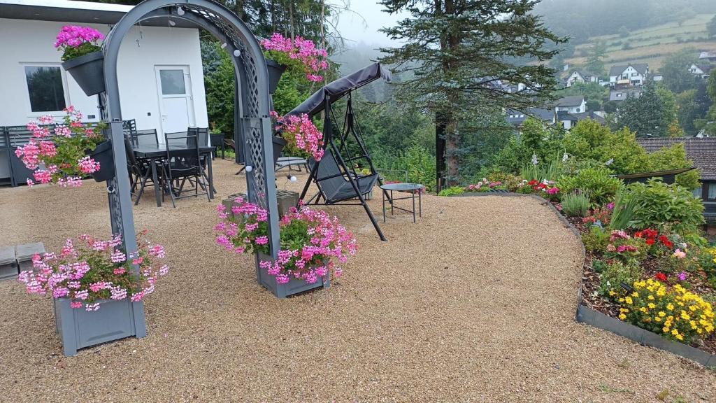 a garden with flowers and a swing at Traumhaus in der Eifel in Hellenthal