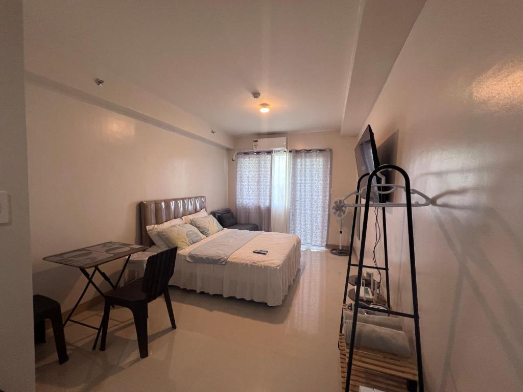 a bedroom with a bed and a desk and a ladder at Iloilo Condo Sm City Style Residences in Iloilo City