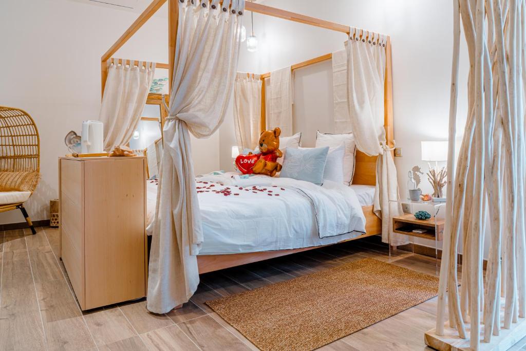 a teddy bear sitting on a bed in a bedroom at Suites Romantiques avec Jacuzzi - Marne-La-Vallée - Le Jardin De Vos Secrets in Mouroux