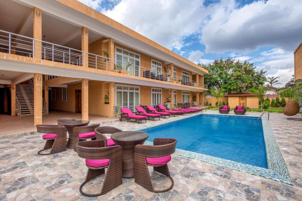 a resort with a pool and chairs and a building at The Green of Oysterbay in Dar es Salaam